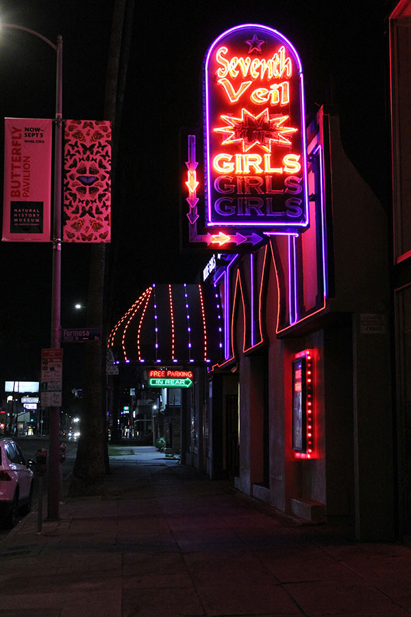 A dimly lit strip club with neon lights, ready for a VR experience.