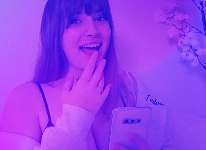 Woman smiling while looking at her phone